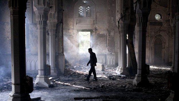 A man walks through Rabaa al-Adawia mosque the day after Egyptian security forces removed the protesters - 15 August 2013