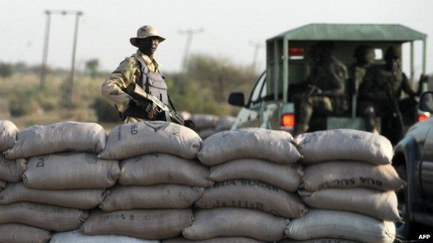 An officer of the Joint Military Task Force (JTF) stands beside sand bags at a road block in the north-eastern Nigerian city of Maiduguri on 30 April 2013