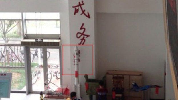 This image shows a model rocket that has been placed in front of Zhou Yongkang's signature