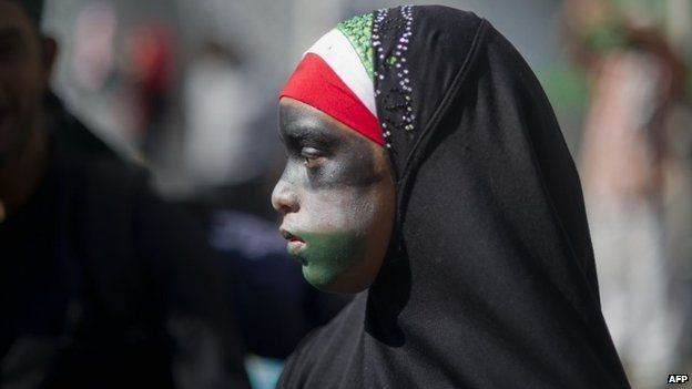 A girl wearing a hijab and with her face painted in the colours of the Palestinian flag takes part in a march in Cape Town on 9 August 2014