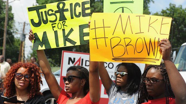 Protestors hold up signs calling for justice after the police shooting in Ferguson, Missouri.