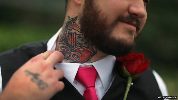 A man shows off his neck tattoo