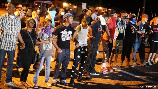 Demonstrators in Ferguson, Missouri, link arms to protest the shooting of Michael Brown - 13 August 2014