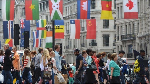 People crossing a London street with flags