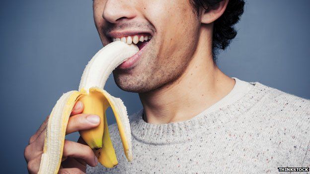 man consuming a banana