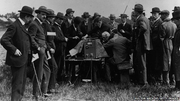 1st June 1919: A group of men crowd round the Marconi wireless telephony fields installation, presumably listening for news of developments as the end of World War I approached. (Photo by Hulton Archive/Getty Images)