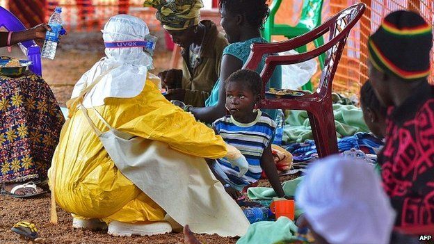 An medical worker feeds a child who is infected with the Ebola virus at a Medecins Sans Frontieres facility in Kailahun, Sierra Leone - 15 August 2014