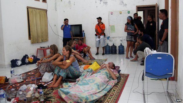 Survivors rest at a house near to the Indonesian town of Bima on 17 August, 2014 after being rescued when their tourist boat sank