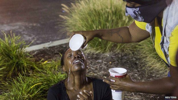 Woman has water poured over her face after a tear gas attack in Ferguson (17 August 2014)