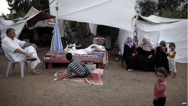 Displaced Palestinian families rest in the grounds of a makeshift camp inside the Al-Shifa hospital gardens in Gaza City