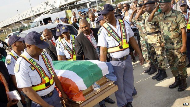 South African police carry the coffin containing the remains of anti-apartheid and former Drum magazine journalist Nat Nakasa at the King Shaka International airport on 19 August 2014 in Durban, South Africa