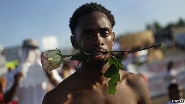 A demonstrator protesting against the fatal shooting of Michael Brown holds a rose in his mouth in Ferguson, Missouri August 19, 2014
