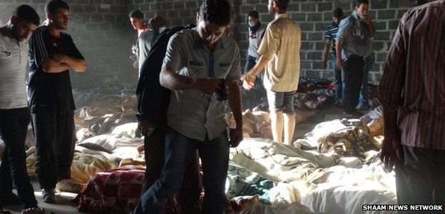 Activists inspect the bodies of men, women and children after the 21 August chemical weapons attack in Damascus