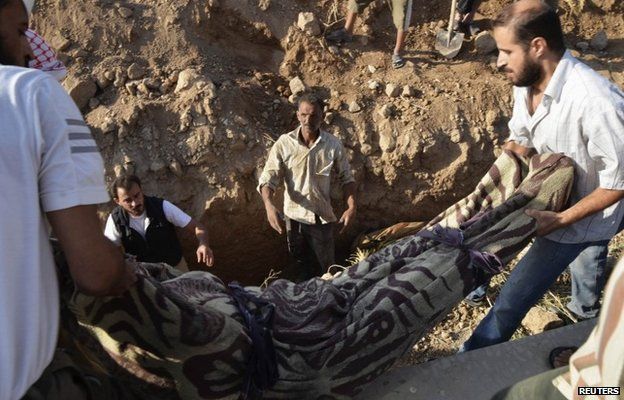 Men bury a victim of the 21 August chemical weapons attack in Damascus