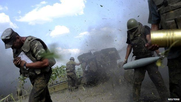 Ukrainian soldiers take cover while firing a cannon towards separatists near Pervomaisk, Luhansk - 20 August 2014