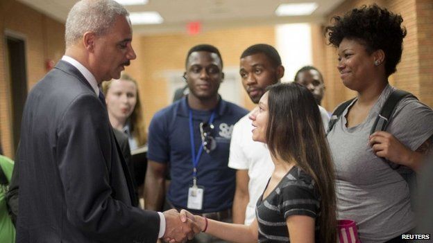 Attorney General Eric Holder shakes hands with Bri Ehsan, 25, following his meeting with students at St. Louis Community College Florissant Valley in Ferguson, Missouri 20 August 2014