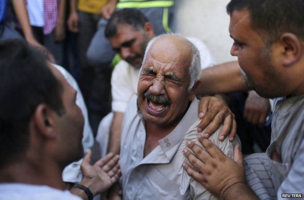 The grandfather of three children killed by an Israeli air strike weeps outside a morgue in Gaza City, 21 August
