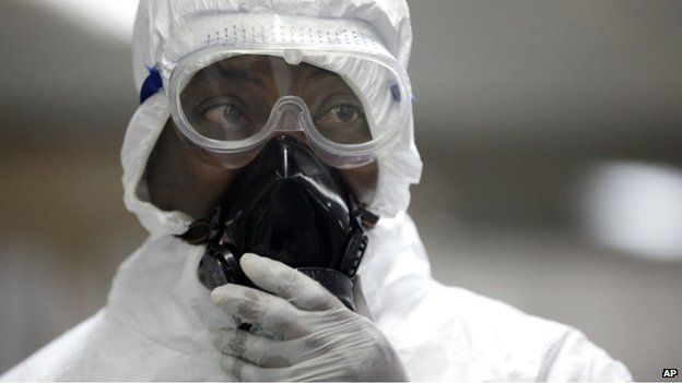 A health official wears a mask to protect from Ebola at a Nigerian airport