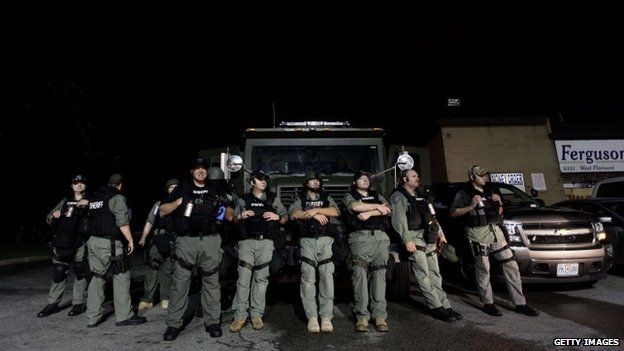 Police watch as demonstrators protest the shooting death of Michael Brown August 20, 2014 in Ferguson, Missouri