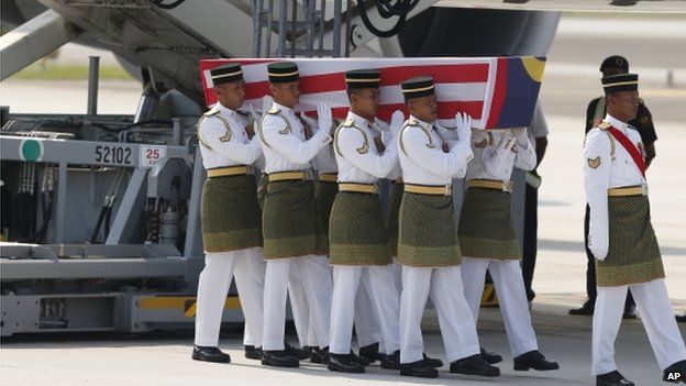 Malaysian Army soldiers carry a coffin containing one of the bodies of the downed MH17 flight upon arrival at Kuala Lumpur International Airport in Sepang, Malaysia, Friday, 22 August 2014