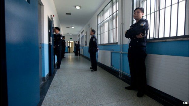 Police guards stand in a hallway inside the No.1 Detention Center during a government guided tour in Beijing on 25 October 2012.