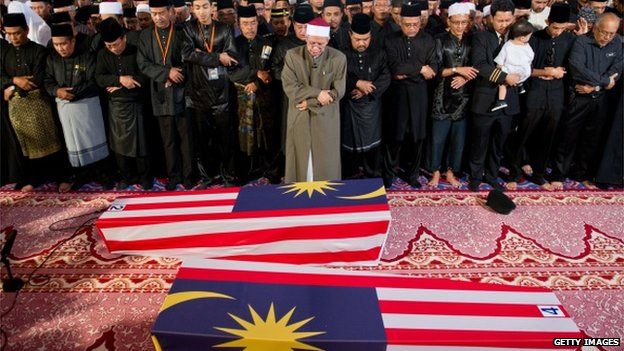 Malaysian Muslim and family members offer special prayers for the remains of co-pilot Ahmad Hakimi Hanapi (L) and flight attendant Nur Shazana Mohamed Salleh (R), the Malaysians who perished aboard flight MH17 that was downed in eastern Ukraine at a mosque in Putrajaya, outside Kuala Lumpur on 22 August 2014