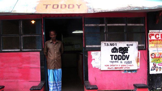This picture taken on February 25, 2011, shows the shopkeeper posing at a Toddy shop selling palm wine in Kochi, Kerala,