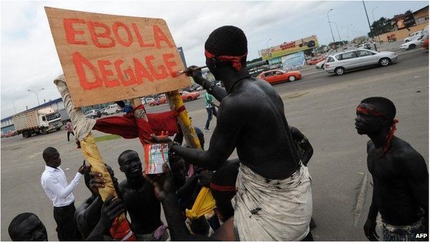 A man with a placard writing "Ebola go away" in Abidjan on 19 August.