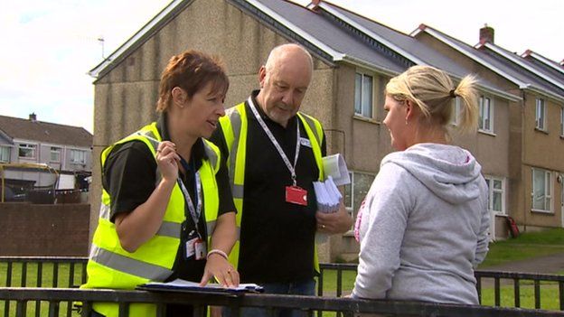 Officers from Tai Calon Community Housing speak to a tenant in Nantyglo