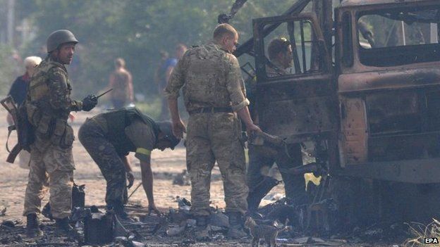 Ukrainian forces check burnt vehicles after rebel shelling, 24 Aug