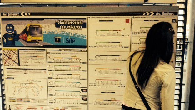 A woman looks at the map of the Transmilenio bus lines in Bogota
