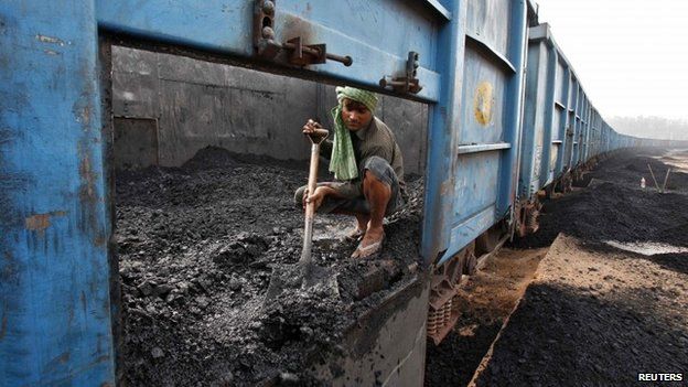 A worker unloads coal from a goods train at a railway yard in the northern Indian city of Chandigarh