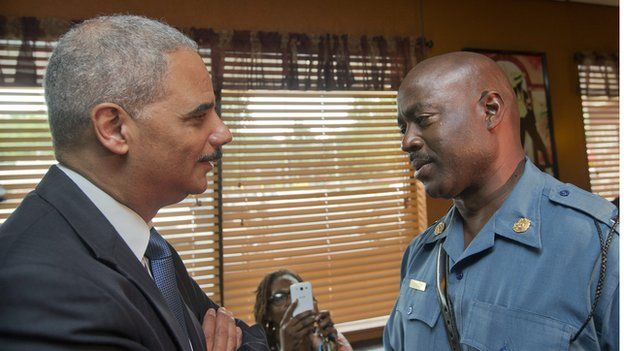 US Attorney General Eric Holder (L) talks with Capt. Ron Johnson, right, of the Missouri State Highway Patrol