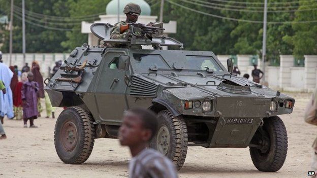 In this file photo taken Thursday, Aug. 8, 2013, a Nigerian soldier patrols in an armoured car, during Eid al-Fitr celebrations, in Maiduguri, Nigeria.