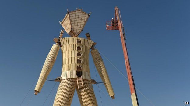 Artists and volunteers work on the "Man" at the annual Burning Man event on the Black Rock Desert of Gerlach, Nevada 24 August 2014