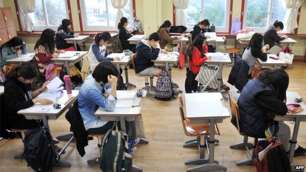 Южнокорейские учащиеся готовятся к сдаче теста на академические способности колледжа, стандартного экзамена для поступления в колледж, в средней школе в Сеуле 7 ноября 2013 г.