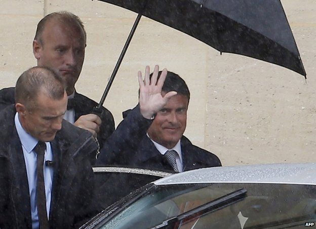 French Prime Minister Manuel Valls waves as he leaves the Hotel Matignon in Paris, 26 August