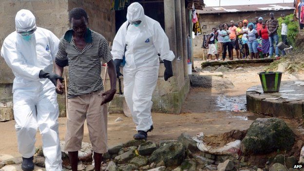 Nurses wearing protective suits escort a man infected with the Ebola virus to a hospital in Monrovia, Liberia - 25 August 2014