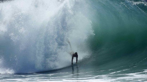A swimmer catches a wave at "The Wedge" wave break in Newport Beach, California 27 August 2014