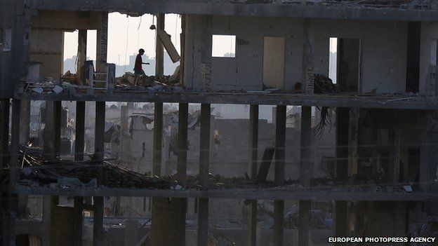 A Palestinian boy inspects his destroyed home that was hit by Israeli war planes in Beit Hanun town in the northern Gaza Strip