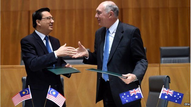Australian Deputy Prime Minister Warren Truss (R) and Malaysian Transport Minister, Liow Tiong Lai shake hands after signing a Memorandum of Understanding (MoU) at Parliament House in Canberra, Australia, 28 August 2014