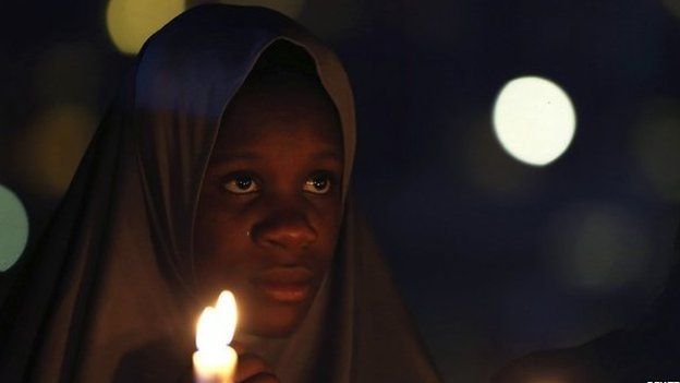A campaigner of "#Bring Back Our Girls" holds candles during a candlelight vigil for Ameyo Stella Adadevoh and other Ebola victims in Abuja August 26, 2014. Adadevoh, a consultant physician and endocrinologist, died after contracting the deadly Ebola virus while treating a Liberian-American, Patrick Sawyer, and other victims of the disease in Nigeria.
