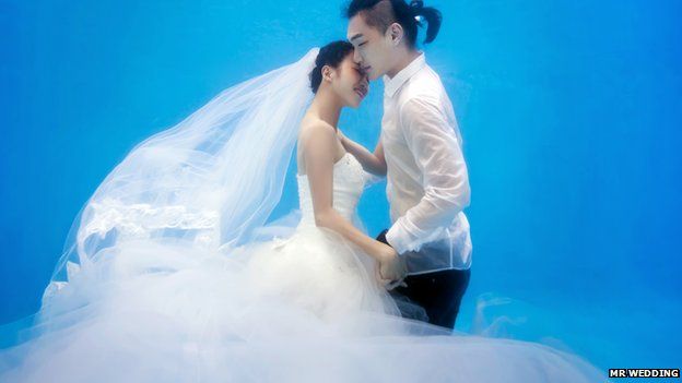 A bride and groom embracing underwater