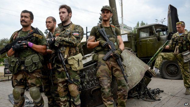 French volunteers on rebel side stand with destroyed Ukrainian equipment