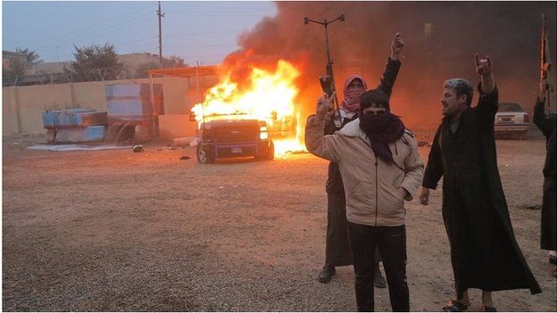 Anti-government protesters in front of burning police vehicle in Ramadi (file photo)