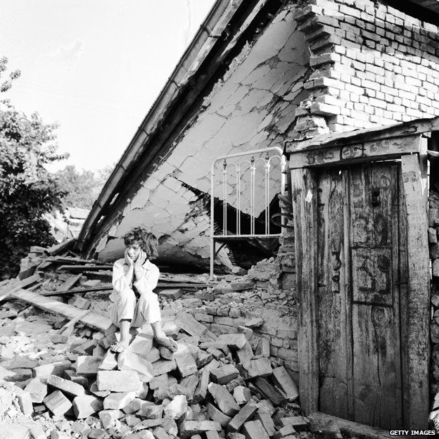 A young girl sits on the rubble of her home which was destroyed during the Skopje earthquake, 1963