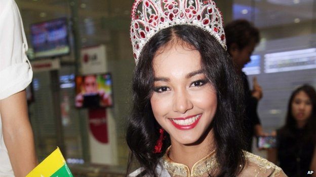 In this 5 June 2014 file photo, Myanmar model May Myat Noe, winner of Miss Asia Pacific World 2014 pageant, waves a miniature flag of the country upon her arrival at Yangon International Airport in Yangon, Myanmar.