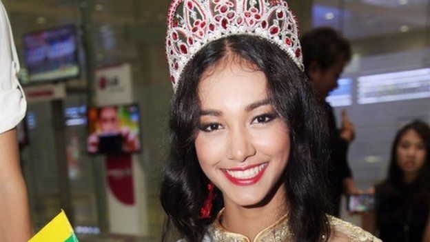 In this 5 June 2014 file photo, Myanmar model May Myat Noe, winner of Miss Asia Pacific World 2014 pageant, waves a miniature flag of the country upon her arrival at Yangon International Airport in Yangon, Myanmar.