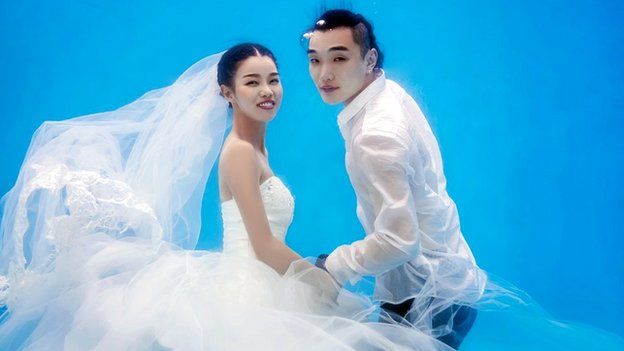 Bride and groom-to-be having their wedding photos taken underwater