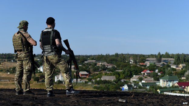 Ukrainian loyalist fighters from the Azov Battalion stand guard on a hill on the outskirts of Mariupol on August 30